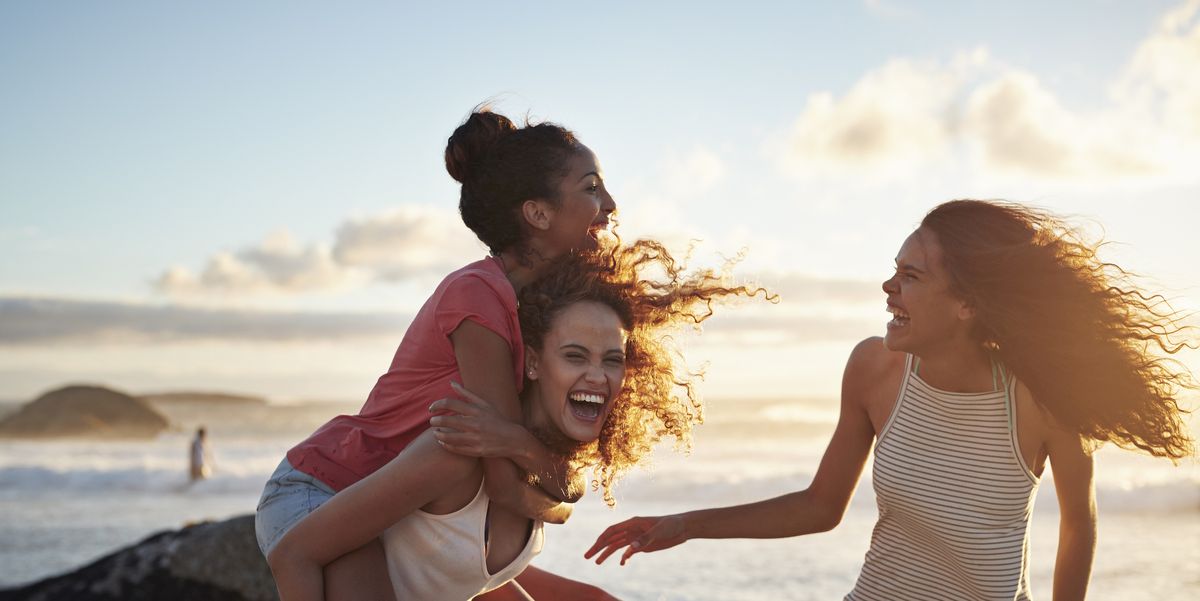 young women piggybacking on sandy beach royalty free image 1592511589